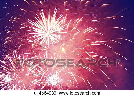 Stock Photo - Fireworks exploding in sky, low angle view, long exposure. Fotosearch