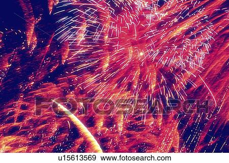 Stock Photo - Fireworks exploding in sky, low angle view, long exposure. Fotosearch