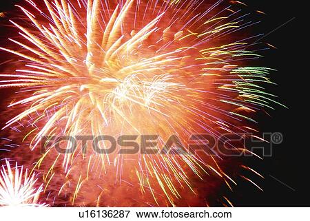 Stock Photo - Fireworks exploding in sky, low angle view, long exposure. Fotosearch