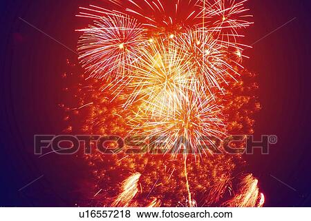 Stock Photo - Fireworks exploding in sky, low angle view, long exposure. Fotosearch