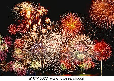 Stock Photo - Fireworks exploding in sky, low angle view, long exposure. Fotosearch