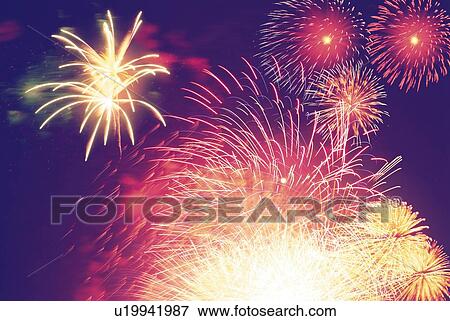 Stock Photo - Fireworks exploding in sky, low angle view, long exposure. Fotosearch