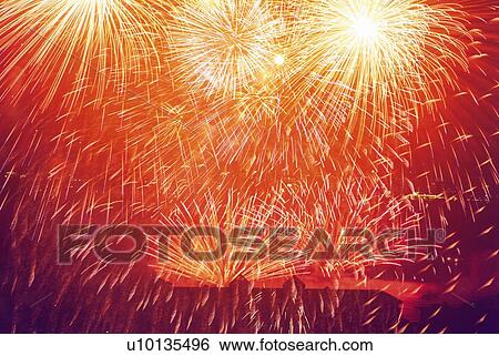 Stock Photograph - Fireworks exploding in sky, low angle view, long exposure. Fotosearch
