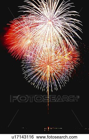 Stock Photograph - Fireworks exploding in sky, low angle view, long exposure. Fotosearch