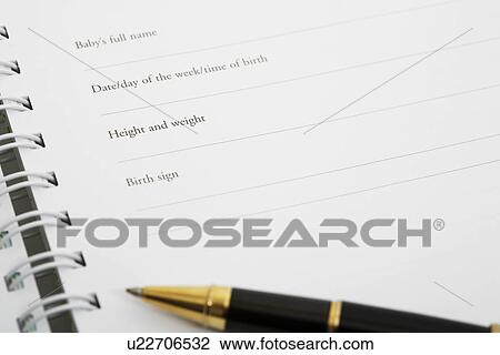 Stock Image - Pen on baby memory book (close-up). Fotosearch
