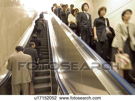 Stock Image - Carrying, Holding, Moving Down, Escalator, Indoor. Fotosearch