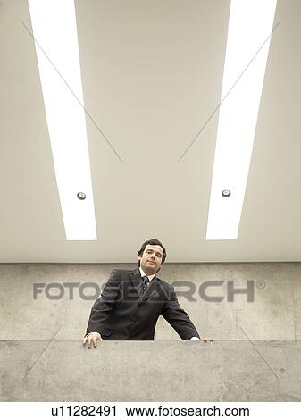 Businessman under strip lights (portrait, low angle view) View Large Photo Image Stock Image - Businessman under strip lights (portrait, low angle view). Fotosearch