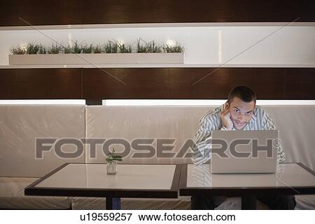 Stock Photo - Man with laptop computer on café table (portrait). Fotosearch