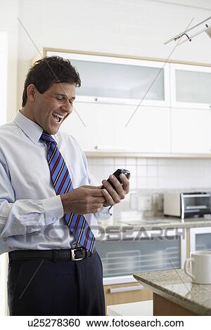 Stock Image - Mature man reading text message. Fotosearch
