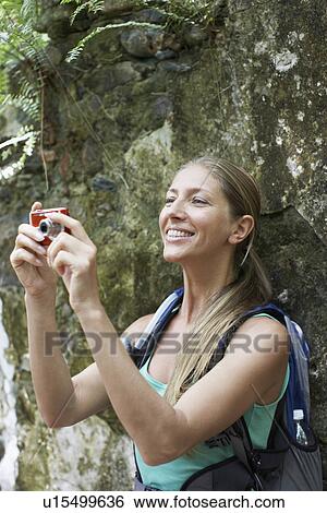 Stock Photograph - Female hiker taking photograph. Fotosearch