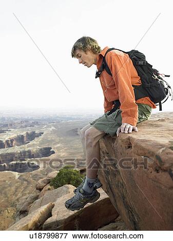 Male hiker looking down on cliff View Large Photo Image Stock Photo - Male hiker looking down on cliff. Fotosearch