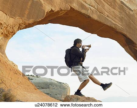 Stock Image - Male hiker playing bugle. Fotosearch