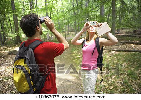 Man and woman watching birds in forest View Large Photo Image Stock Photograph - Man and woman watching birds in forest. Fotosearch