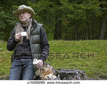 Stock Photo - Man Drinking Coffee in Field. Fotosearch