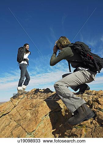 Man Taking Photograph of Woman on Boulders View Large Photo Image Stock Image - Man Taking Photograph of Woman on Boulders. Fotosearch