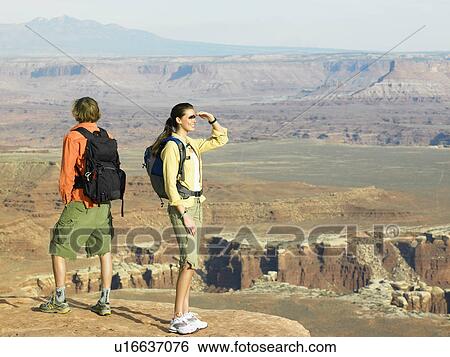 Two hikers looking at rock strata View Large Photo Image Stock Photograph - Two hikers looking at rock strata. Fotosearch