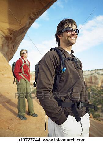 Picture - Two men hiking on red rocks. Fotosearch