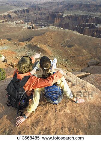 Young couple with backpacks looking at rock strata on cliff View Large Photo Image Stock Photography - Young couple with backpacks looking at rock strata on cliff. Fotosearch