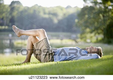 Man lying on lawn View Large Photo Image Stock Image - Man lying on lawn. Fotosearch