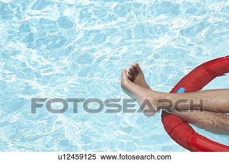 Man's legs on inflatable mattress in swimming pool View Large Photo Image Stock Photography - Man's legs on inflatable mattress in swimming pool. Fotosearch