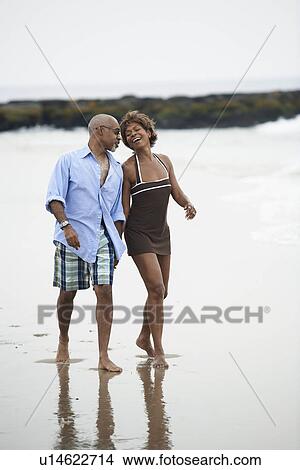Picture - Mature couple walking at beach. Fotosearch