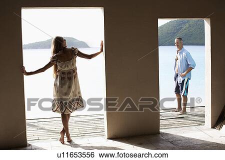 Stock Photograph - Mid adult couple in beach hut. Fotosearch