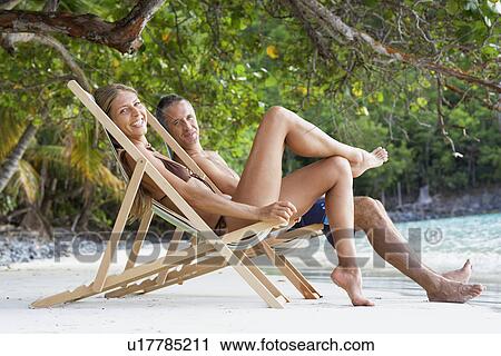 Mid adult couple on lounge chairs on sandy beach, St. John, US Virgin Islands, USA View Large Photo Image Stock Image - Mid adult couple on lounge chairs on sandy beach, St. John, US Virgin Islands, USA. Fotosearch