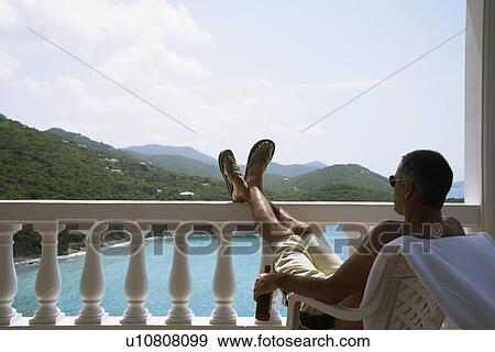 Mid adult man looking at view from balcony, St. John, US Virgin Islands, USA View Large Photo Image Stock Photo - Mid adult man looking at view from balcony, St. John, US Virgin Islands, USA. Fotosearch