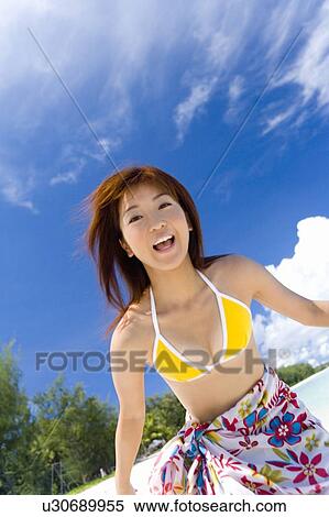 Stock Photography - Portrait of a young woman on beach, smiling, Saipan, USA . Fotosearch