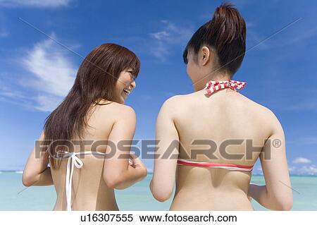 Two women standing on beach, smiling, Saipan, USA View Large Photo Image Stock Photography - Two women standing on beach, smiling, Saipan, USA . Fotosearch