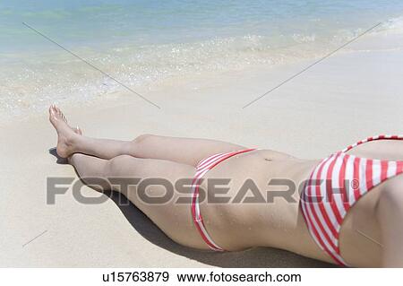 Stock Photo - Woman lying on beach, Saipan, USA . Fotosearch