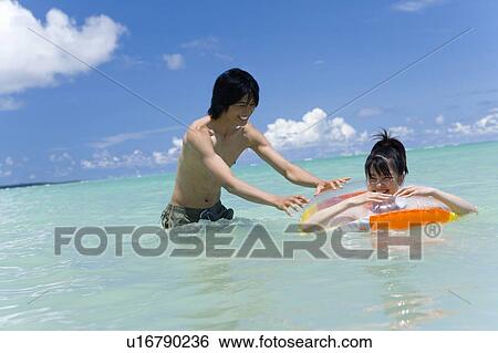 Stock Photograph - Young couple in the sea, Saipan, USA . Fotosearch