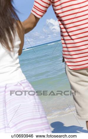 Young couple standing on beach, Saipan, USA View Large Photo Image Stock Photograph - Young couple standing on beach, Saipan, USA . Fotosearch
