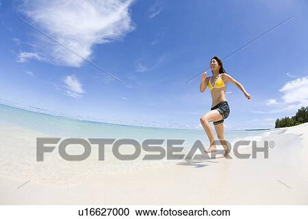Young woman running on beach, fish-eye lens, Saipan, USA View Large Photo Image Stock Image - Young woman running on beach, fish-eye lens, Saipan, USA . Fotosearch