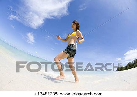 Young woman running on beach, fish-eye lens, Saipan, USA View Large Photo Image Stock Photography - Young woman running on beach, fish-eye lens, Saipan, USA . Fotosearch