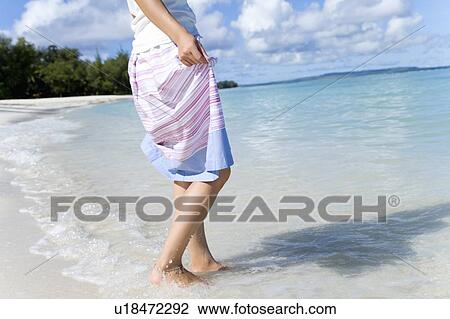 Stock Image - Young woman walking on beach, Saipan, USA . Fotosearch