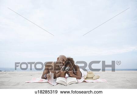 Mature couple looking at digital camera on beach View Large Photo Image Stock Photo - Mature couple looking at digital camera on beach. Fotosearch