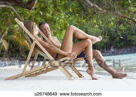 Mid adult couple on lounge chairs on sandy beach, St. John, US Virgin Islands, USA View Large Photo Image Stock Photo - Mid adult couple on lounge chairs on sandy beach, St. John, US Virgin Islands, USA. Fotosearch
