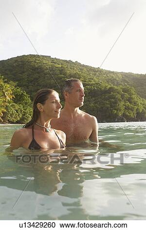 Mid adult couple standing in ocean and looking at view, St John, US Virgin Islands, USA View Large Photo Image Stock Image - Mid adult couple standing in ocean and looking at view, St John, US Virgin Islands, USA. Fotosearch