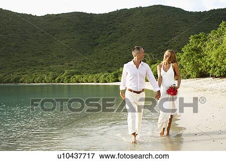 Stock Photo - Newlyweds walking on beach, St. John, US Virgin Islands, USA. Fotosearch