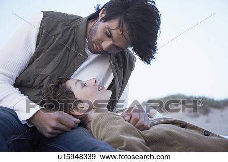 Young couple looking each other (low angle view) View Large Photo Image Stock Photo - Young couple looking each other (low angle view). Fotosearch