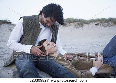 Stock Photo - Young couple on sandy beach. Fotosearch