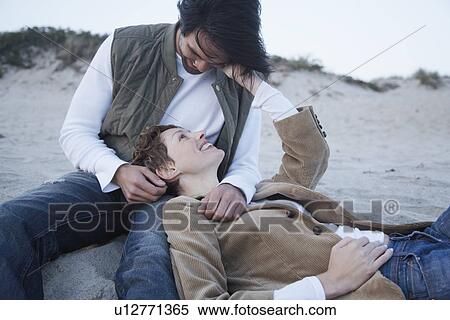 Stock Photography - Young couple on sandy beach. Fotosearch