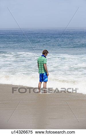 Man standing on beach View Large Photo Image Stock Photography - Man standing on beach. Fotosearch