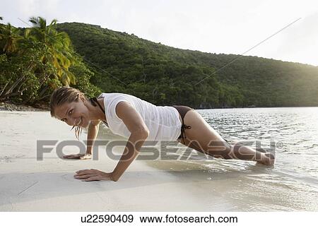 Mid adult woman doing press ups on beach, St. John, US Virgin Islands, USA View Large Photo Image Stock Photo - Mid adult woman doing press ups on beach, St. John, US Virgin Islands, USA. Fotosearch