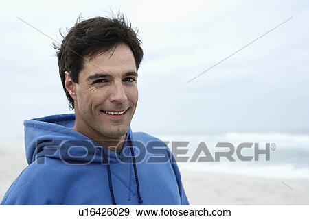 Stock Photo - Portrait of mid adult man on beach. Fotosearch