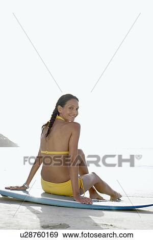 Young woman sitting on surfboard, St. John, US Virgin Islands, USA View Large Photo Image Stock Photo - Young woman sitting on surfboard, St. John, US Virgin Islands, USA. Fotosearch