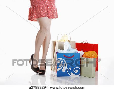 Woman standing by shopping bags (low section) View Large Photo Image Picture - Woman standing by shopping bags (low section). Fotosearch