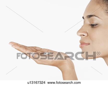 Picture - Young woman holding moisturizing cream on palm of hand. Fotosearch