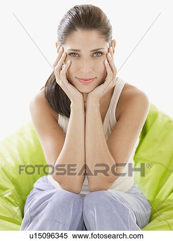 Young woman sitting with chin on hands View Large Photo Image Stock Photography - Young woman sitting with chin on hands. Fotosearch